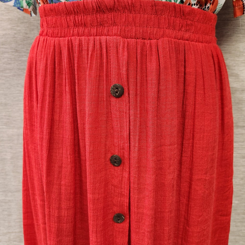 Decorative button detail on red dress skirt