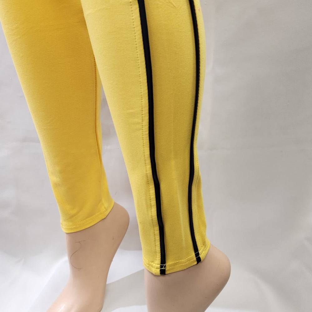 Detailed view of yellow leggings with black piping