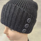 Detailed view of Winter beanie in black with button embellishment on the side