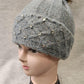 Detailed view of stone studded brim of grey beanie
