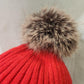 Detailed view of pom pom of red winter beanie