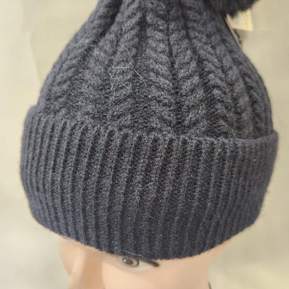 Detailed view of Rope knit black winter beanie with pom pom