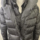 Closer view of zipped front of long winter black puffer jacket 