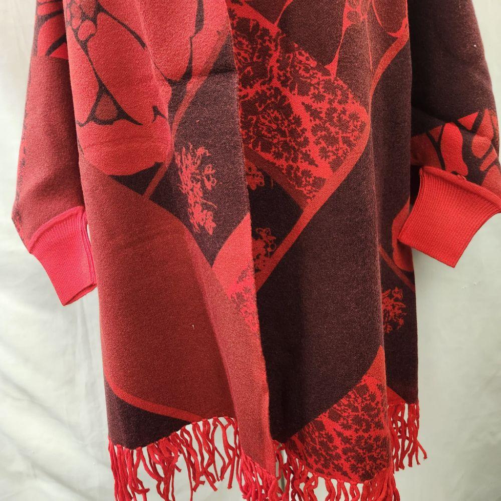 Detailed view of the sleeves of Red and burgundy printed reversible cape
