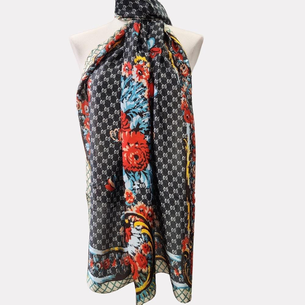 Detailed view of black silky scarf with floral colorful print