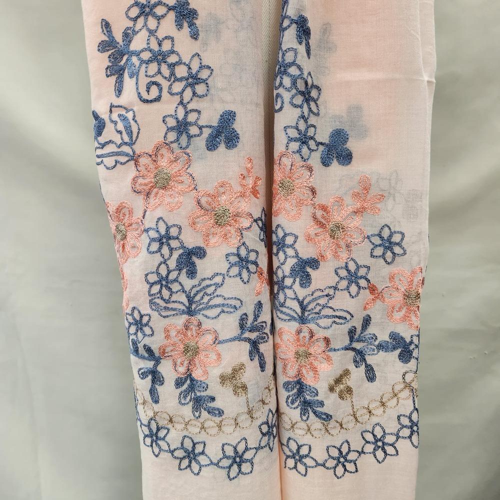 Detailed view of colorful embroidery on light peach summer scarf