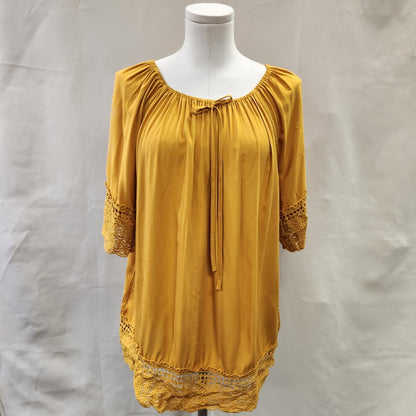 Front view of yellow top with lace detail and gathered round neckline