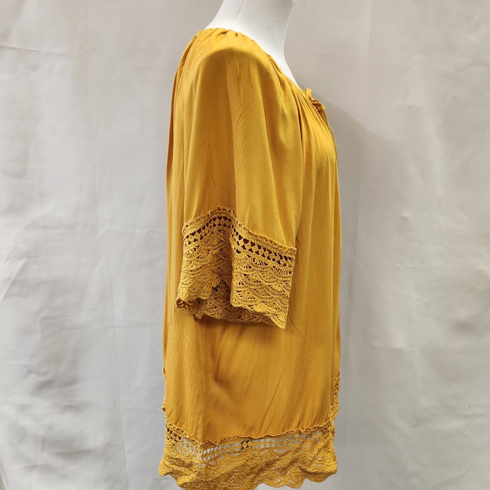 Side view of yellow top with lace detail and gathered round neckline