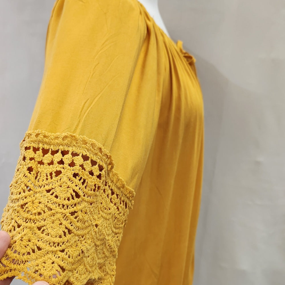 Lace detail around the sleeves of yellow top