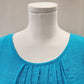 Pleated round neckline of turquoise summer top