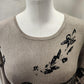 Detailed view of neckline of Closed front printed knitted top in taupe and black 