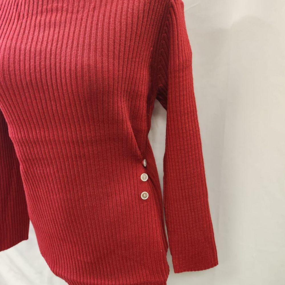 Detailed view of the button embellishment on the side of red sweater