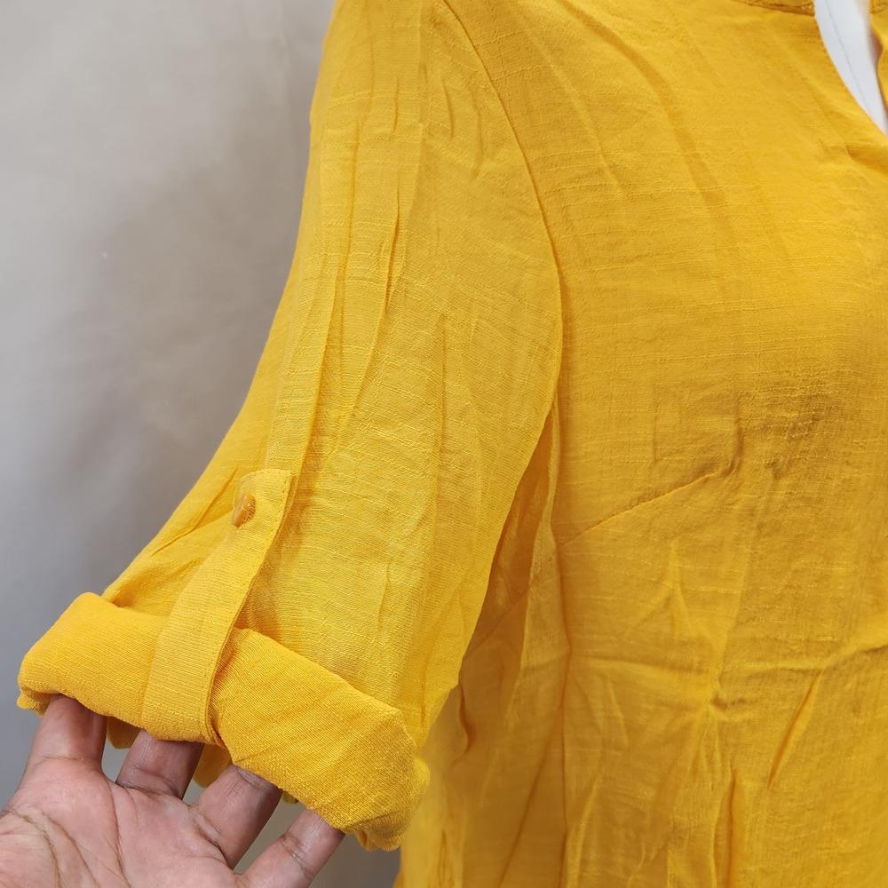 Alternative view of rolled up sleeve of yellow layered top