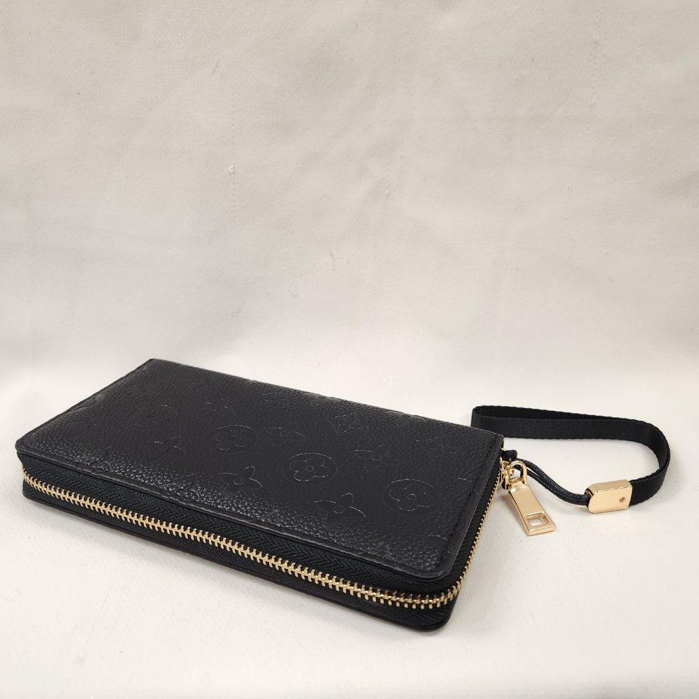 Black wallet with engraved floral pattern and black wrist strap