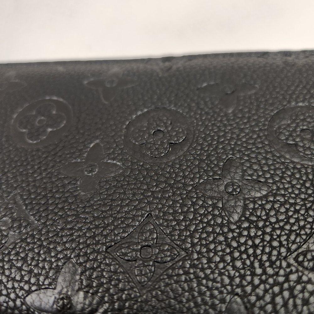 Floral engraved pattern on black wallet with wrist strap