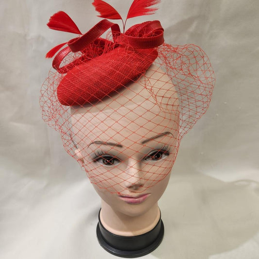 Front view of elegant cambric fascinator in red with veil