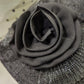 Detailed view of embellishment on black cloche hat 
