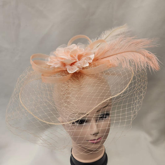Elegant peach colored fascinator with veil