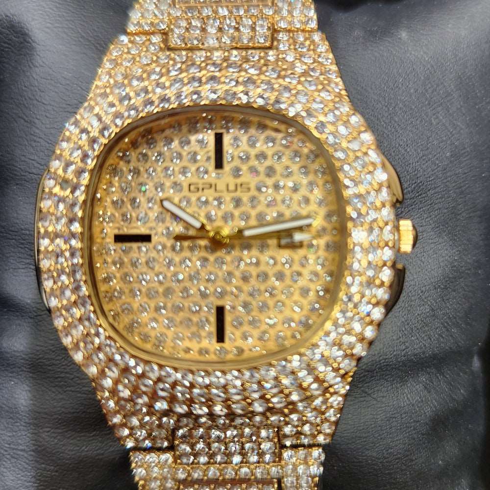 Detailed view of wrist watch in gold with stone embellished strap and dial