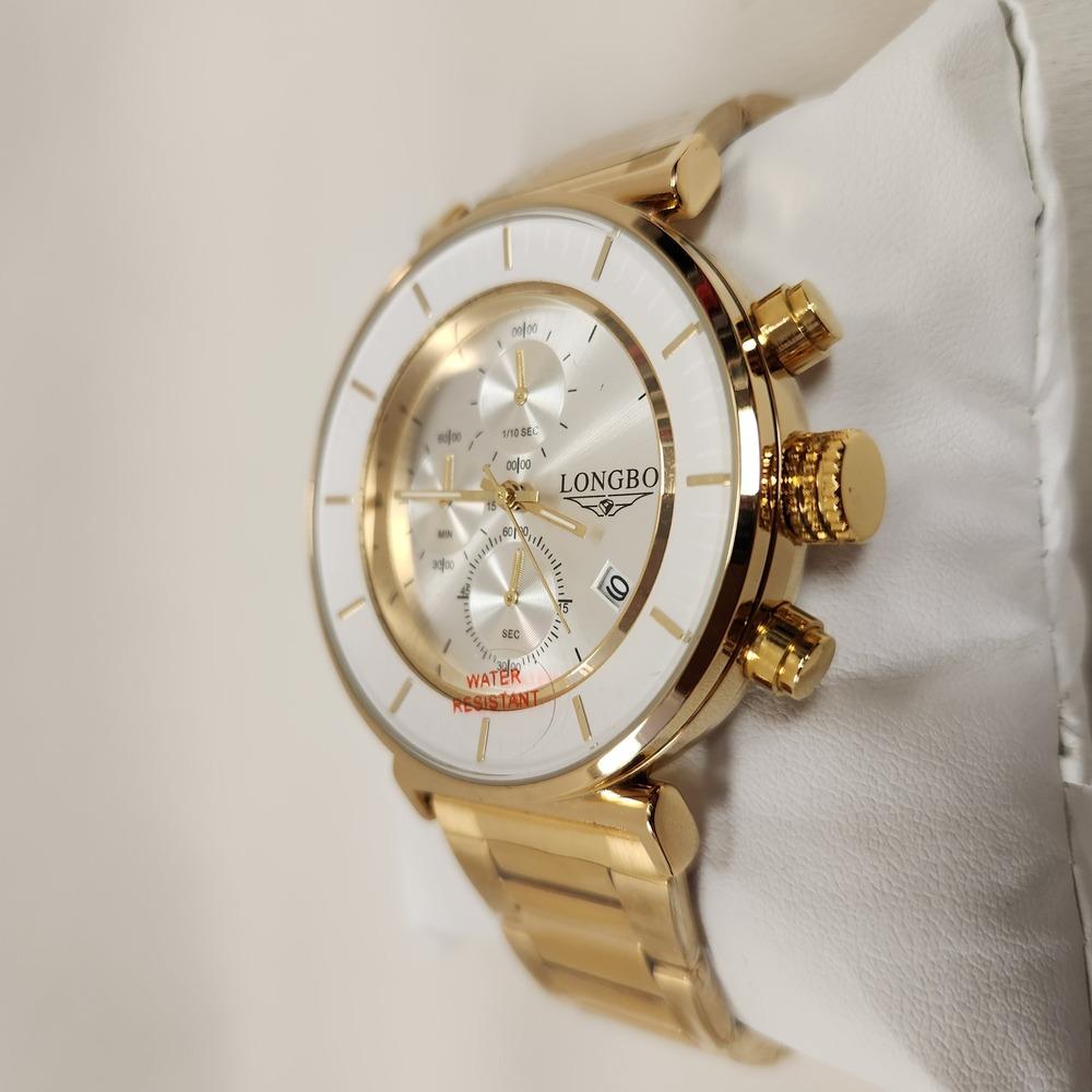 Side view of wrist watch in gold with white round face 