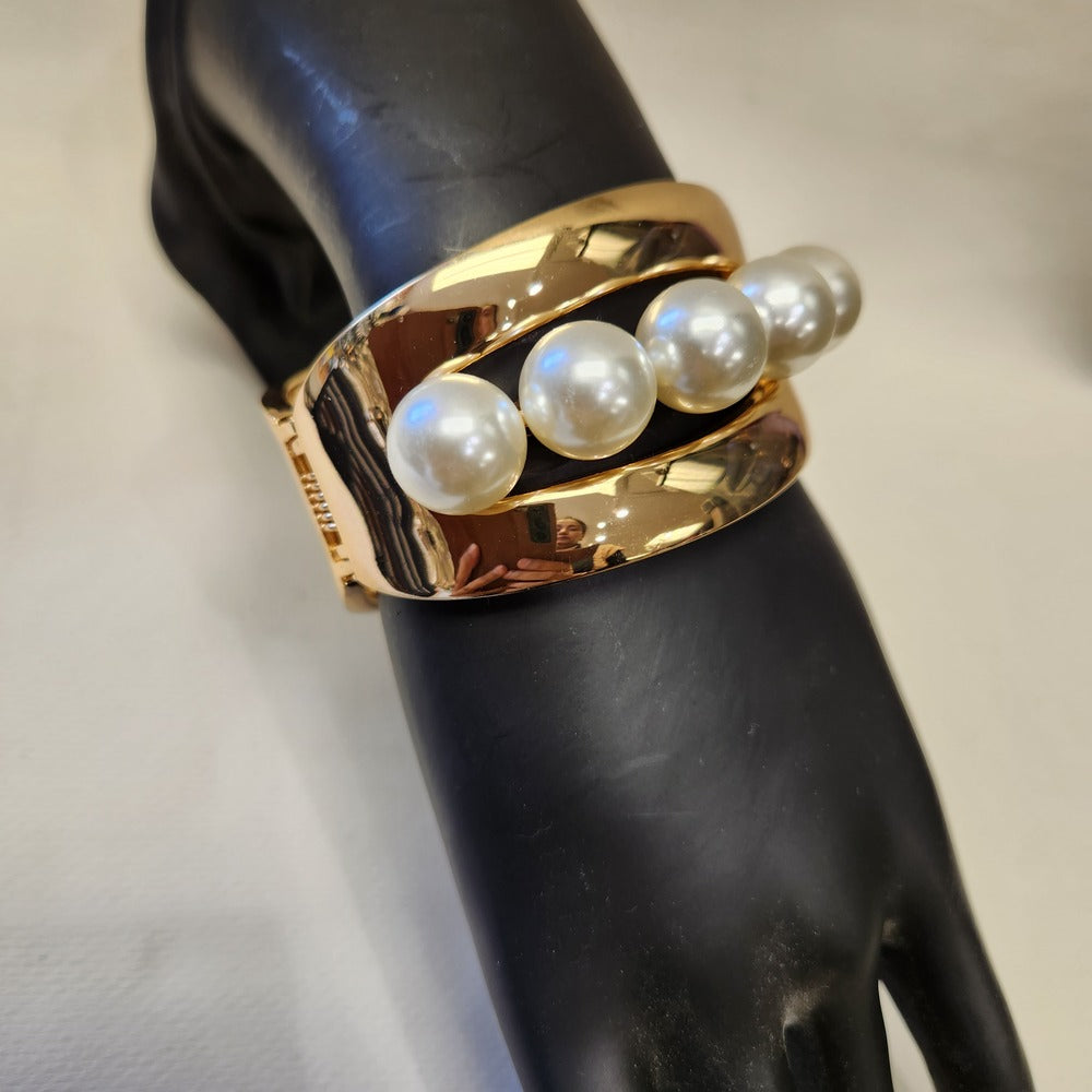 Detailed view of Broad cuff gold bracelet with pearls