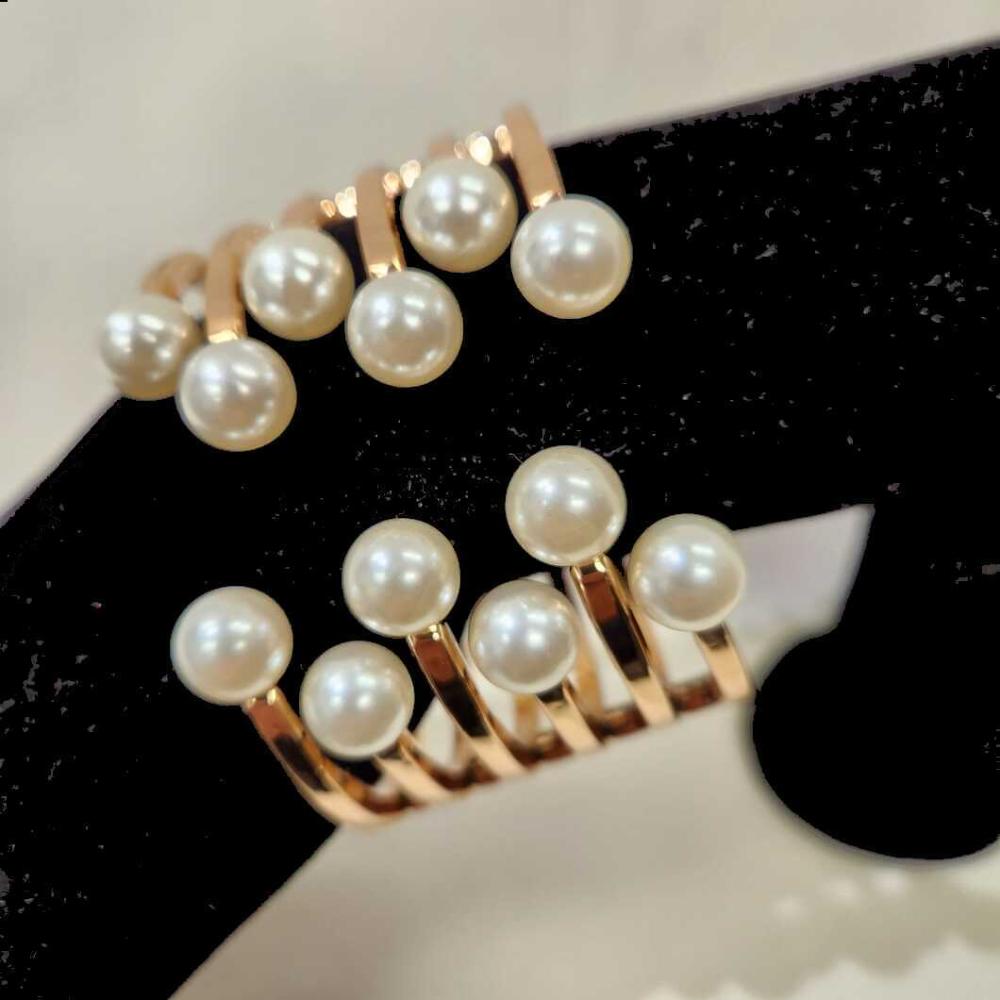 Detailed view of Gold cuff gold bracelet with pearl embellishment