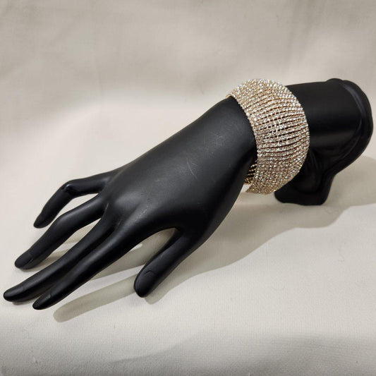 Stone studded gold bracelet with fold over clasp