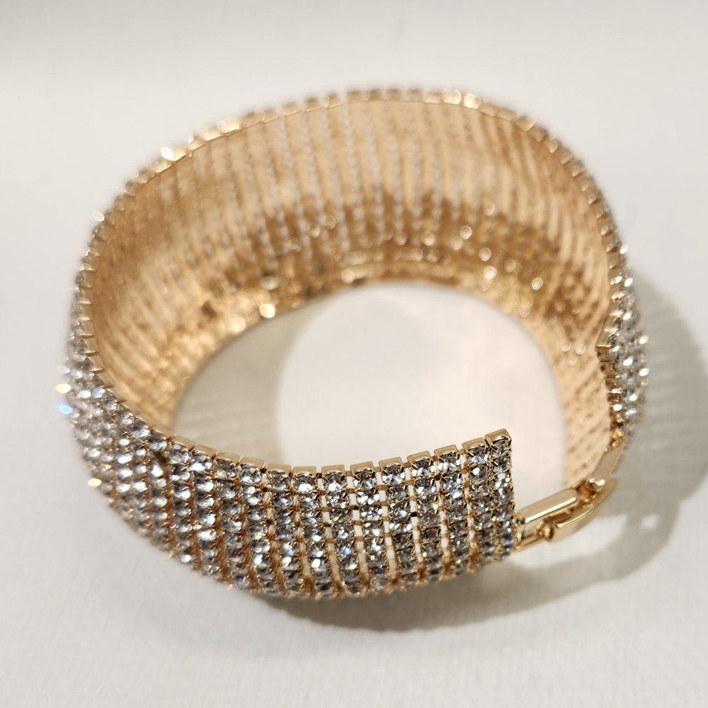 Detailed view of Stone studded gold bracelet with fold over clasp