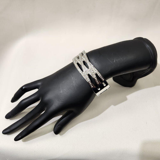 Side view of silver color trendy hinged bracelet with stones