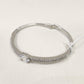 Fold over closure of silver colored dainty bracelets