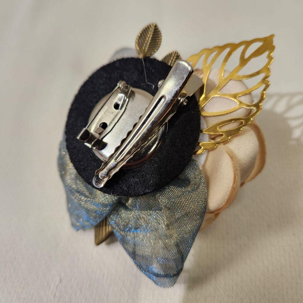Rear view of brooch and hair clip in shades of cream and grey 