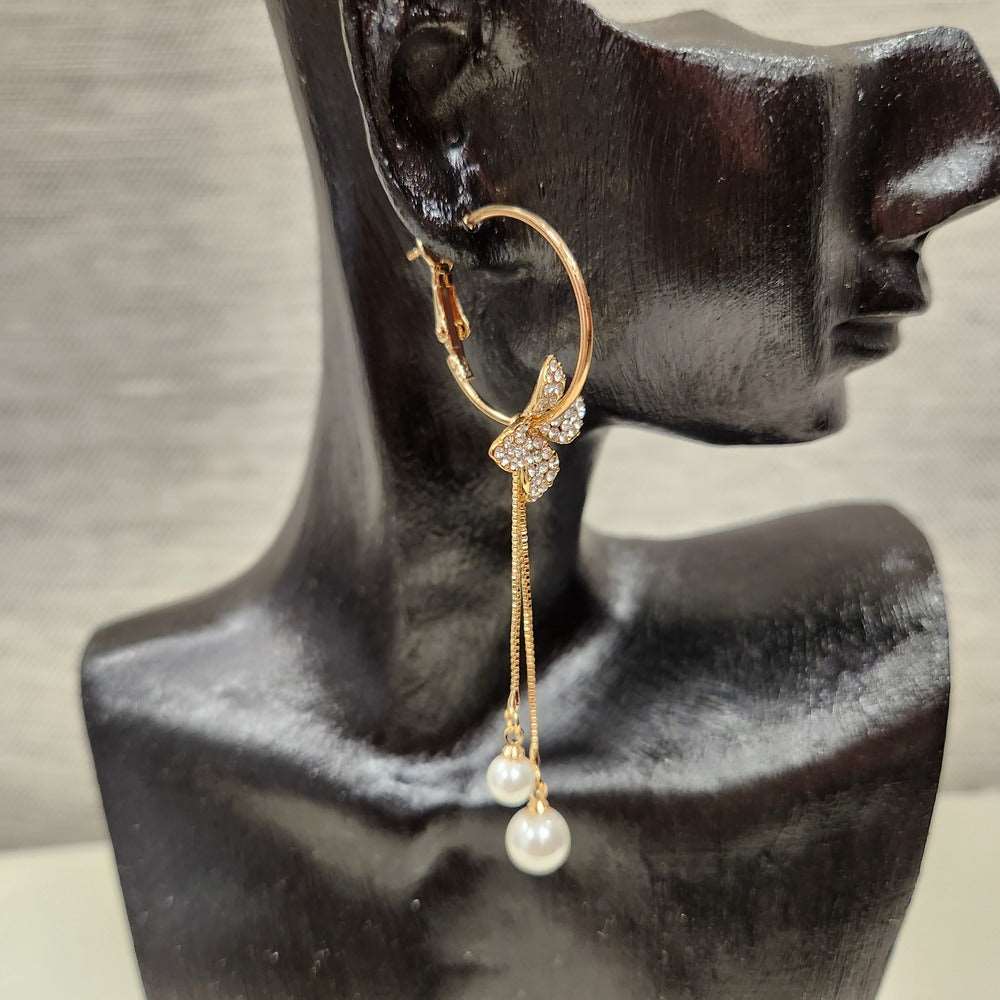 Side view of floral gold drop earrings adorned with pearls and stones