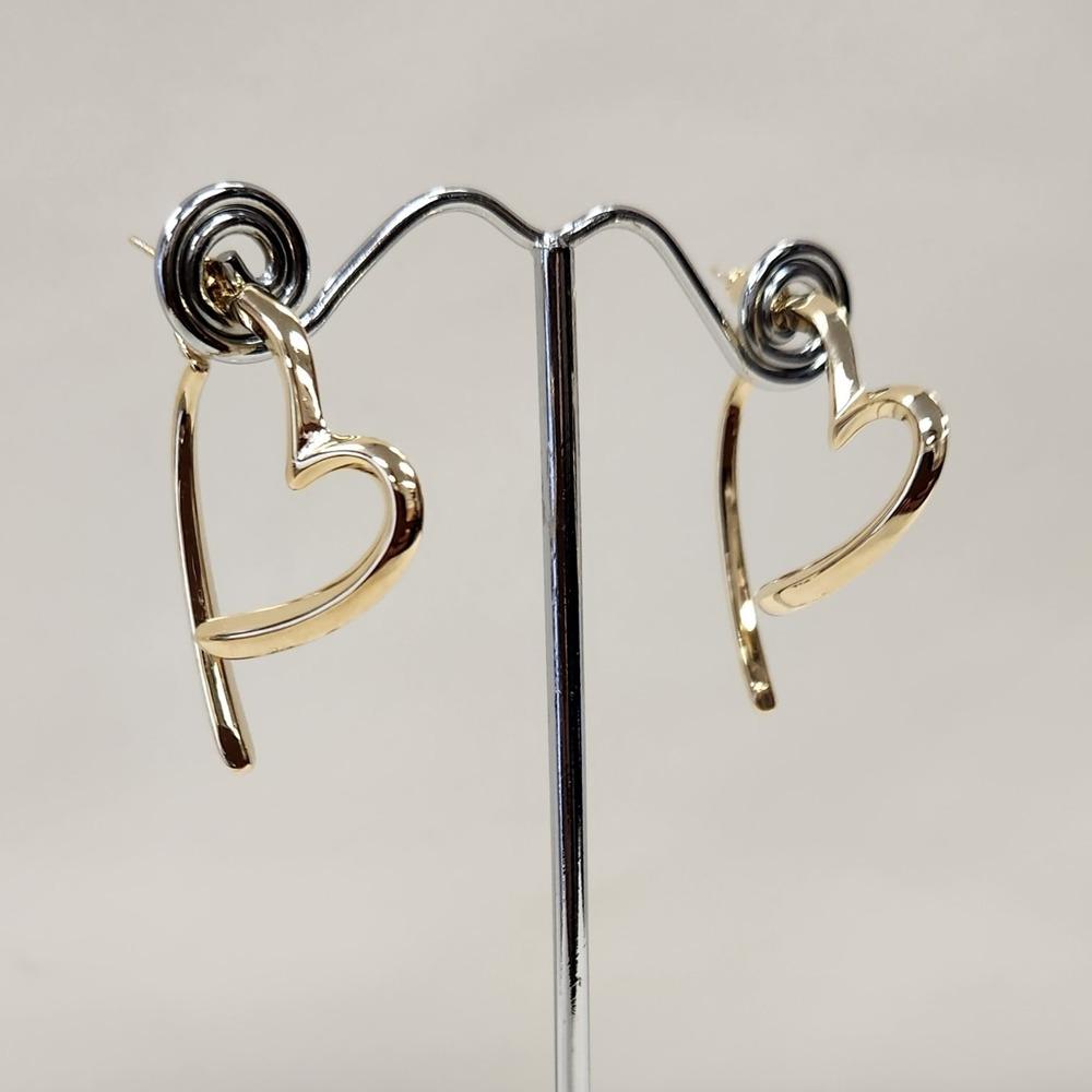 Detailed view of gold color heart shaped drop earrings