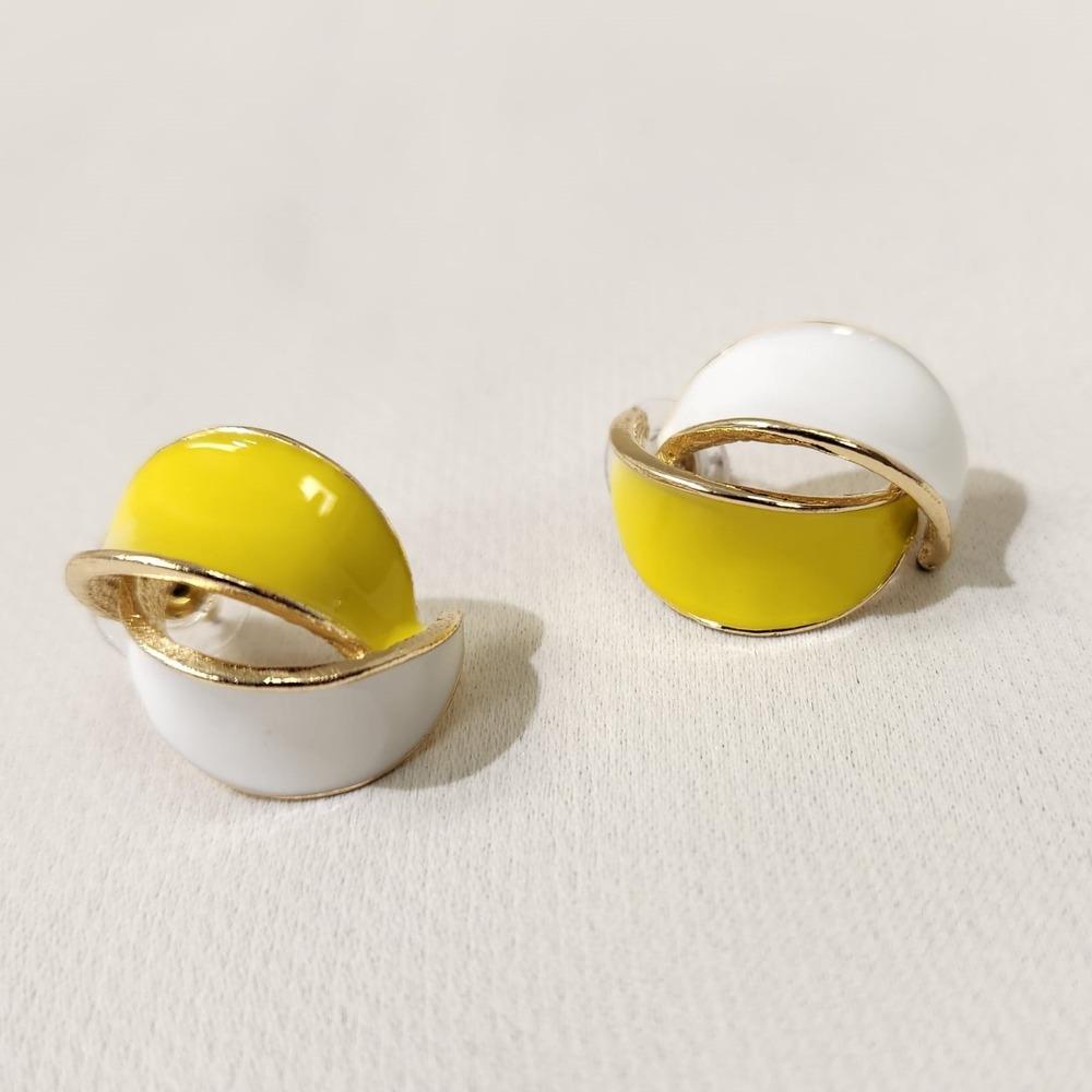 Detailed view of yellow and white enameled stud earrings