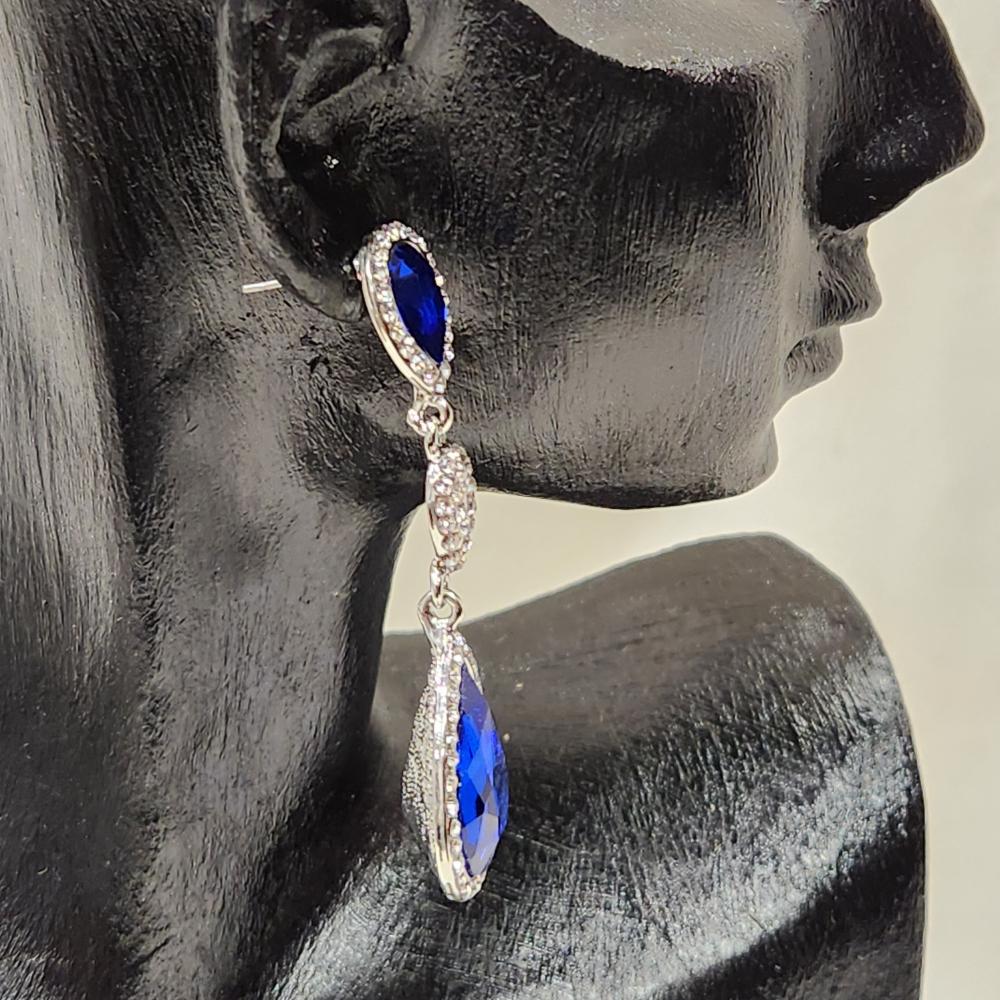 Side view of Silver frame dangle earrings with clear and blue stones