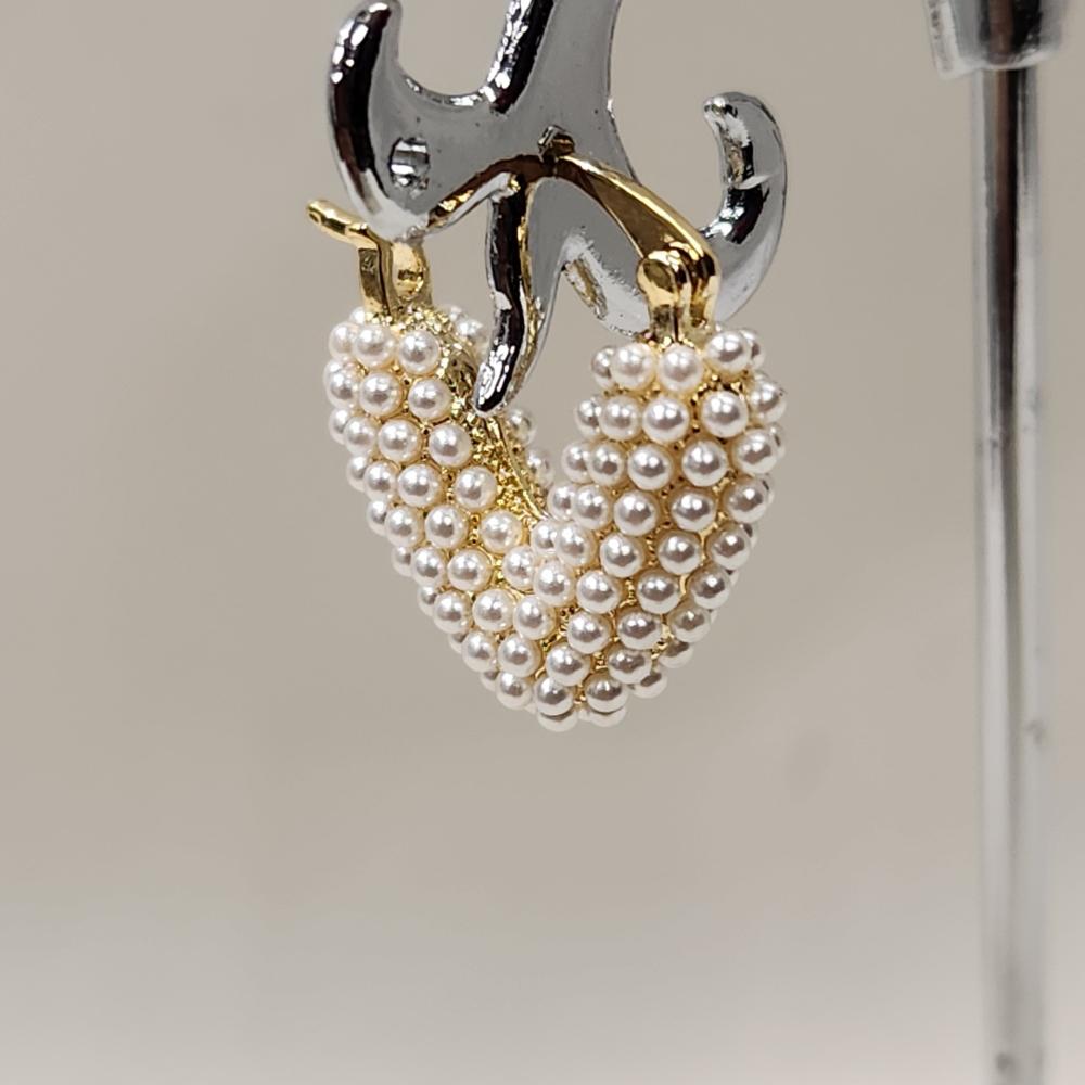Close up of V shaped small hoops with pearls