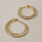 Latch back closure of gold hoop earrings with embossed hearts