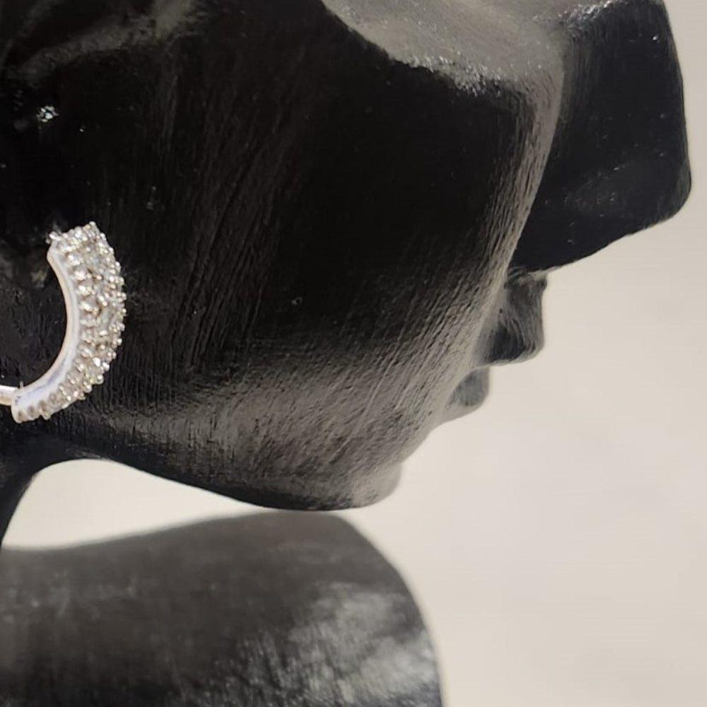 Side view of Stone studded silver hued small size hoop earrings