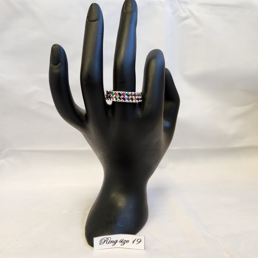 Basket weave ring band with multi colored stones displayed on mannequin stand