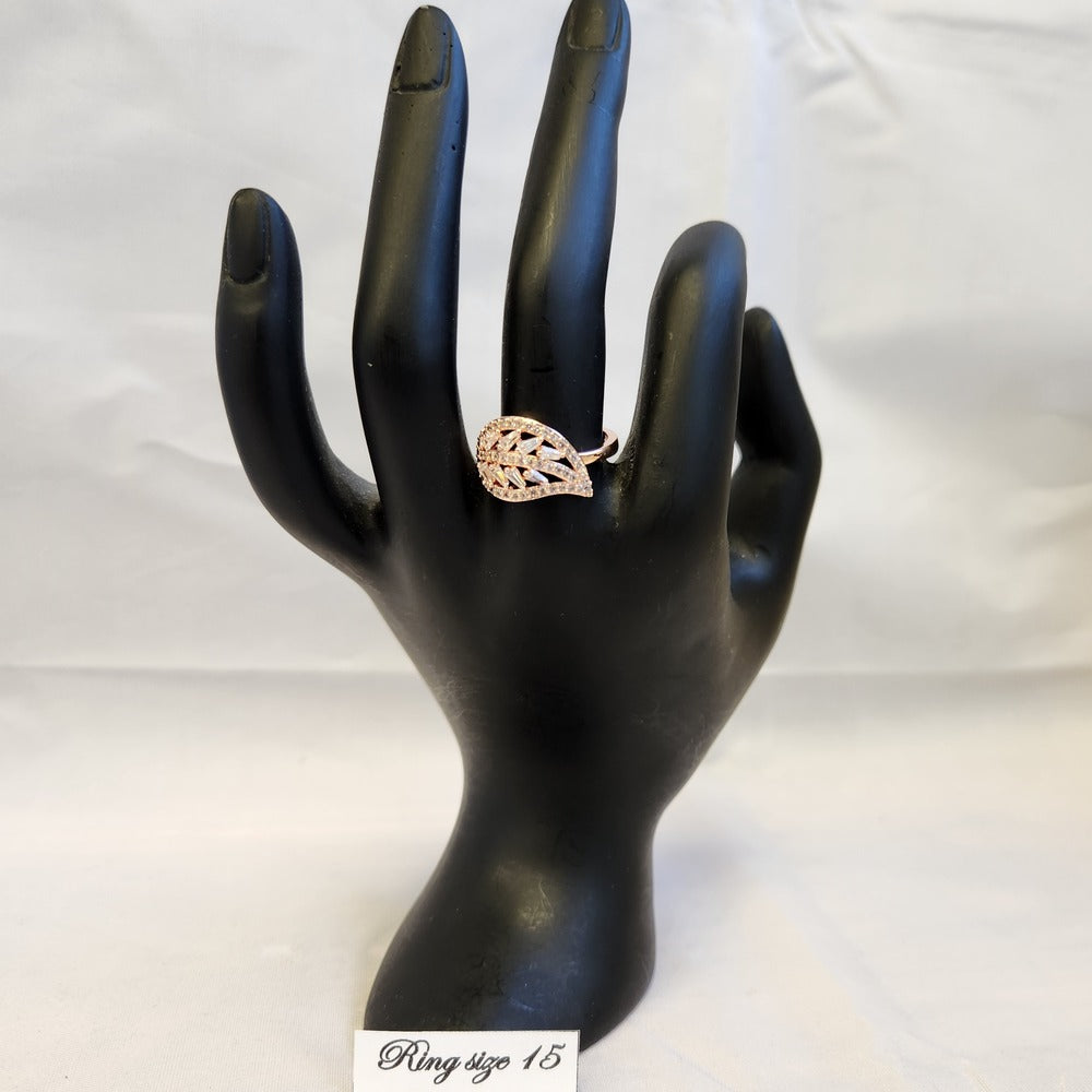 Delicate leaf shaped rose gold stone studded ring on a stand