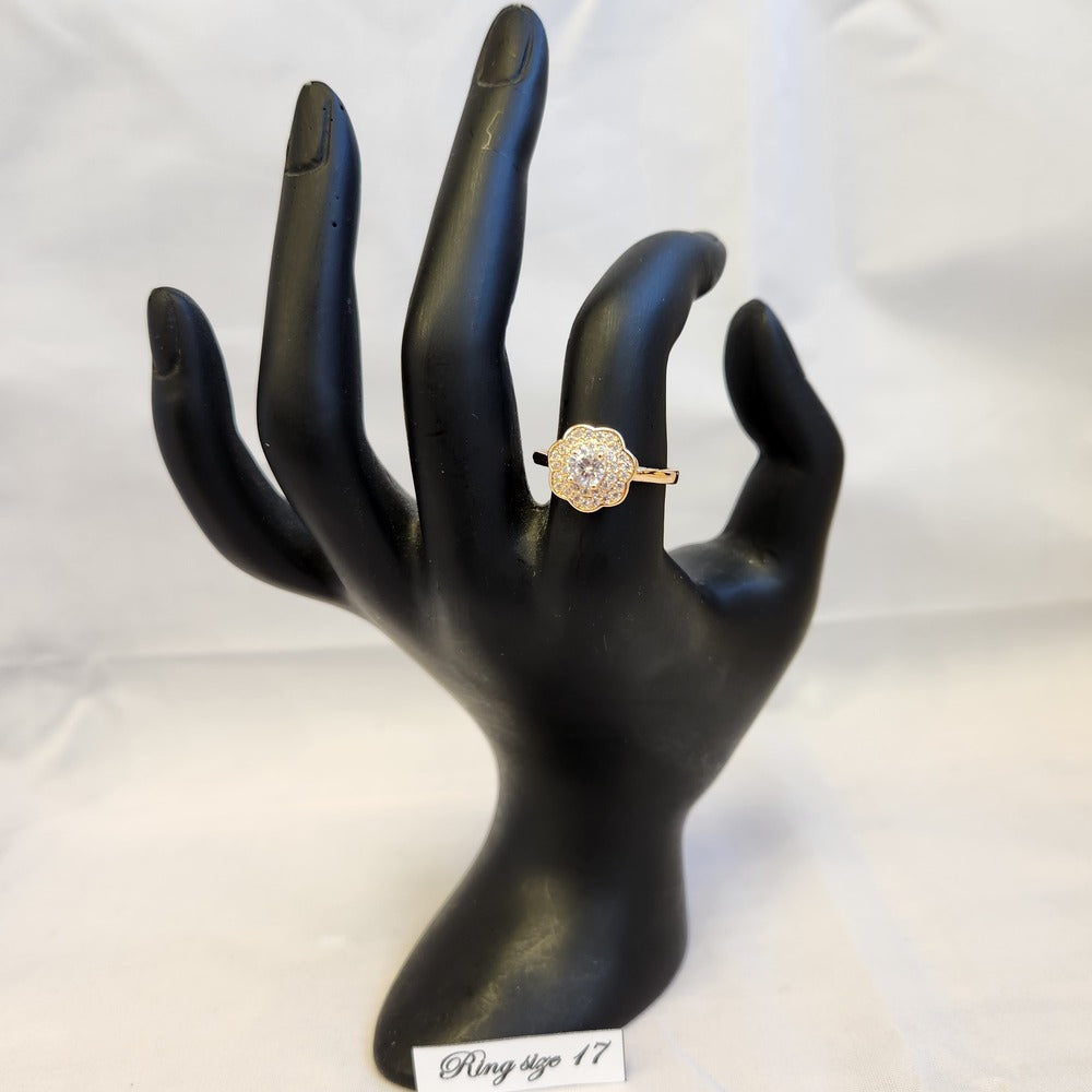 Halo set gold color ring in floral design displayed on a mannequin stand