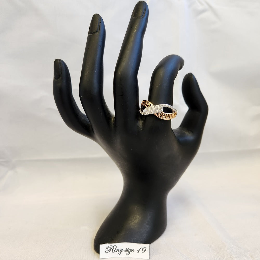 Exquisite gold color ring with fine clear stones displayed on a mannequin stand