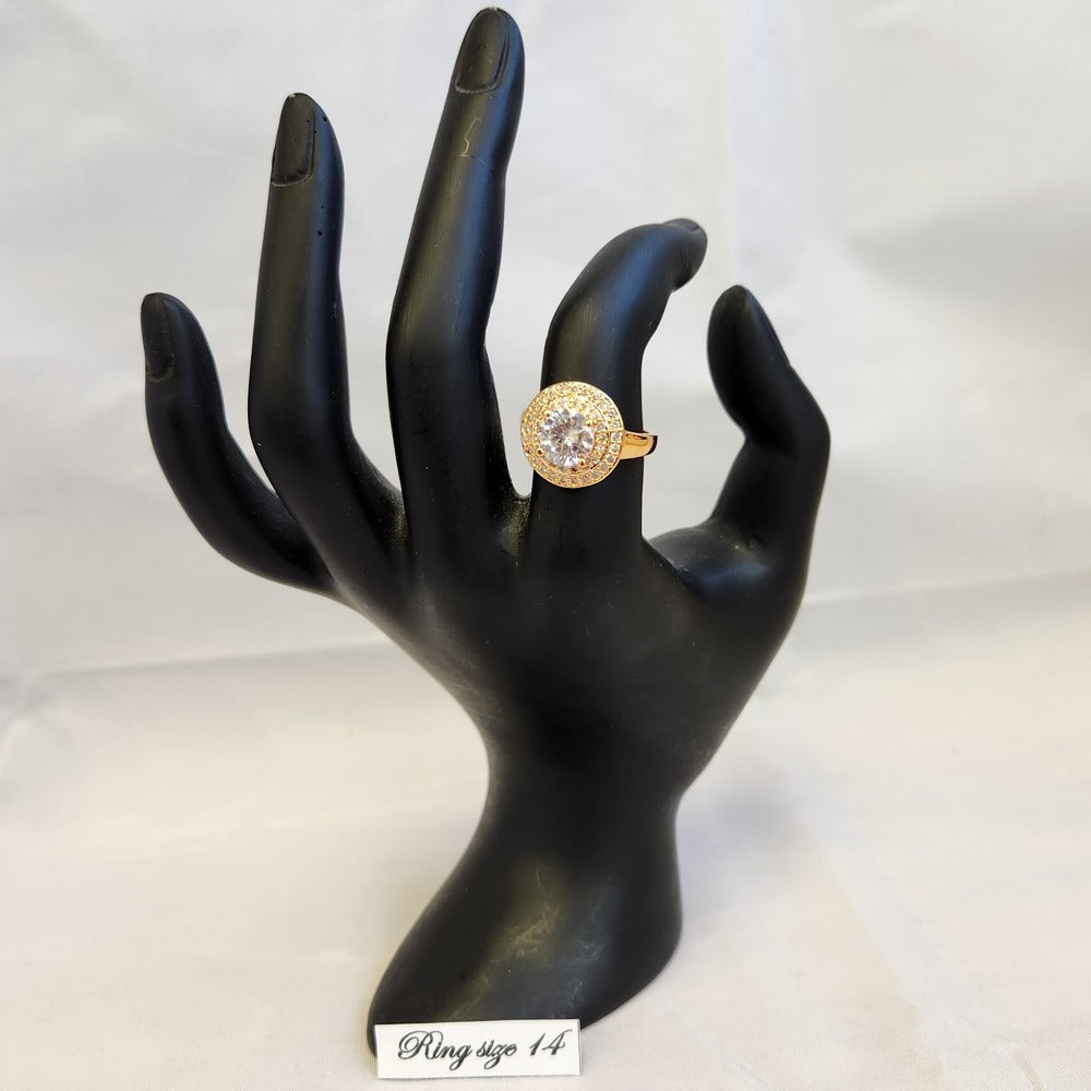 Prong set halo ring in gold colored frame displayed on a mannequin stand