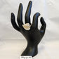 Nature inspired stone studded gold color ring displayed on a mannequin stand