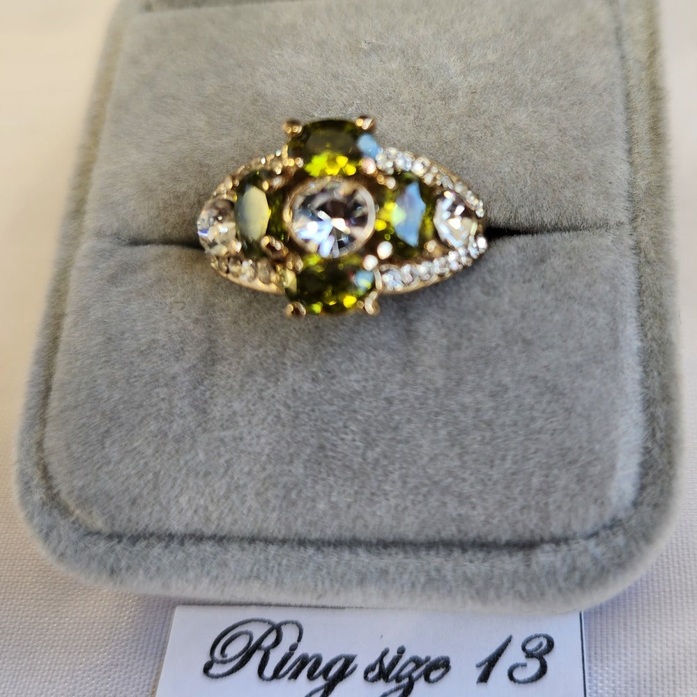Detailed view of ring with clear and green colored stone setting
