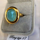 Detailed view of bold gold frame ring with oval turquoise center stone