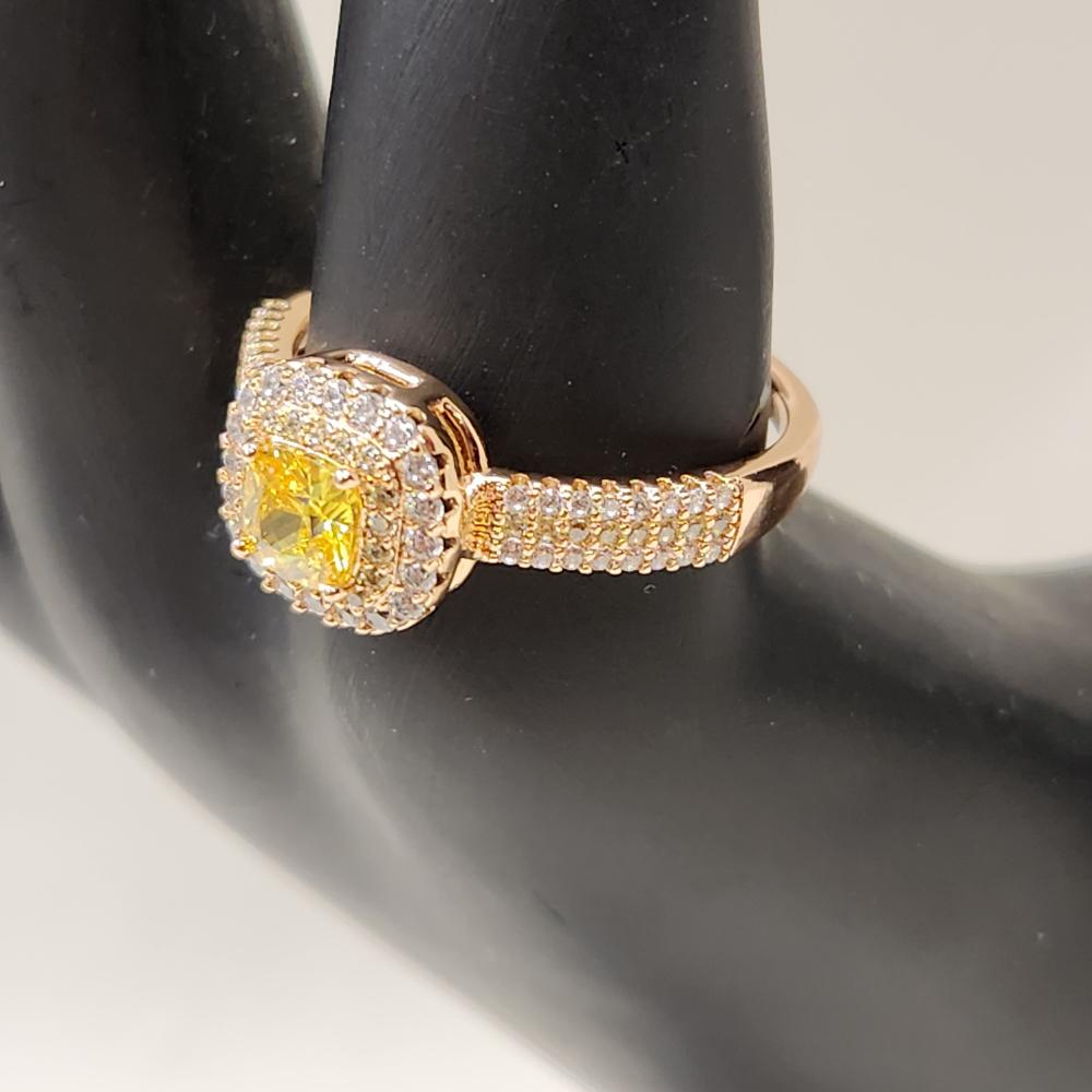 Detailed view of Gold color ring with square shaped yellow center stone