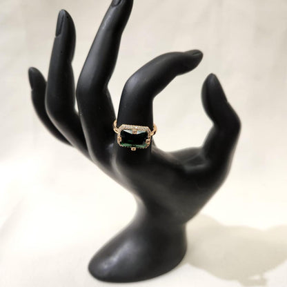 Gold ring with green baguette shaped center stone