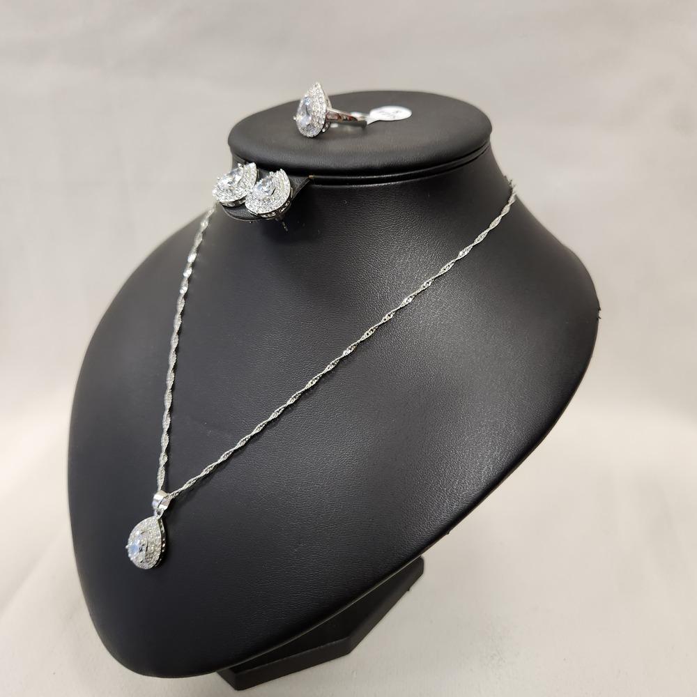 Side view of Four piece silver tone jewelry set with clear stones