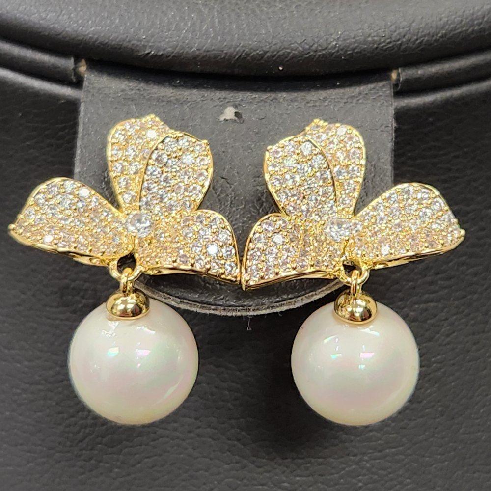 Detailed view of earrings with stones and pearls